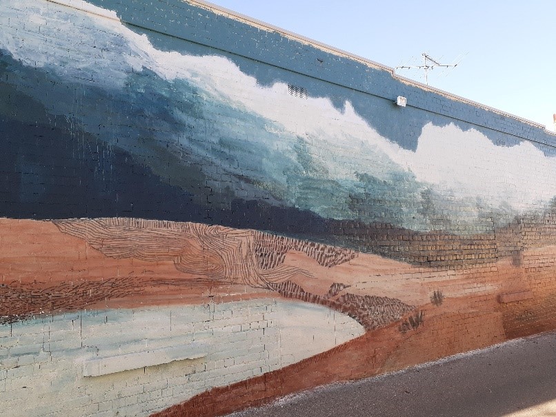 A landscape mural on the wall of an alley way