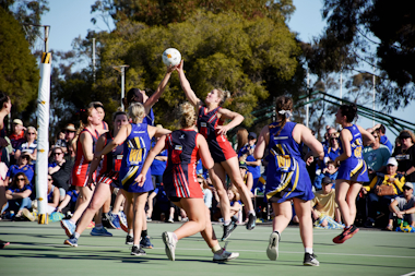 Netballers compete for the ball in the air