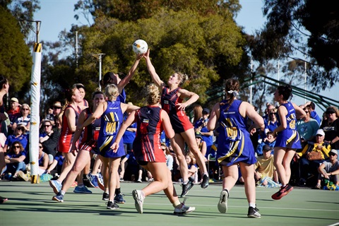 Netballers compete for the ball in the air